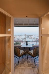 a balcony with a table and chairs and a large window at Aélia Studios in Agia Ermioni
