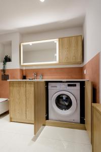 a washing machine in a kitchen with a mirror at Aélia Studios in Agia Ermioni
