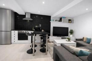 a kitchen and living room with a couch and a table at Casa Vidán completa Santiago Rural in Santiago de Compostela
