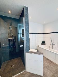 a bathroom with a shower and a tub and a toilet at Alpine View Thierachern in Thierachern +17 photos