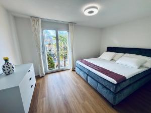 a bedroom with a bed and a desk and a window at Alpine View Thierachern in Thierachern