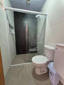 a bathroom with a toilet and a glass shower at El Tata in Arroio do Silva +22 photos