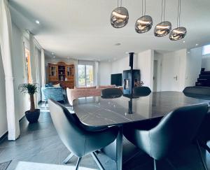 a dining table and chairs in a living room at Alpine View Thierachern in Thierachern
