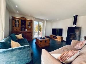 a living room with two couches and a tv at Alpine View Thierachern in Thierachern