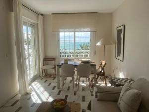 a living room with a table and chairs and the ocean at Apartamento LH Beach frente al mar in La Herradura