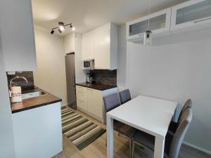 a kitchen with a white table and a white counter top at Cozy studio near the train station in Lappeenranta