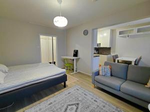 a bedroom with a bed and a couch and a table at Cozy studio near the train station in Lappeenranta
