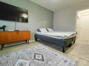 a bedroom with a bed and a tv and a dresser at Cozy studio near the train station in Lappeenranta
