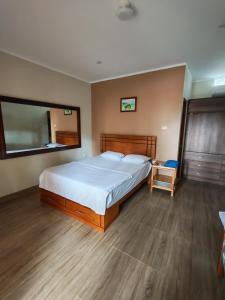 a bedroom with a large bed and a mirror at Hospedaje Máncora in Máncora