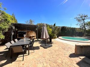 a patio with a table and an umbrella and a pool at Casa Mar in Valencia
