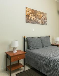 a bedroom with a bed and a table with a lamp at Central Cozy Apartment 3 in Sparta