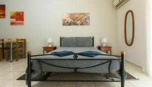 a bed in a room with two tables and a mirror at Central Cozy Apartment 3 in Sparta