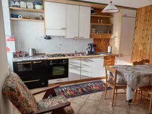a kitchen with a black stove and a table with a tableablish at Appartamento Conti Schreck in Baselga di Pinè