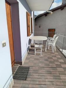 a patio with a table and chairs on a balcony at Appartamento Conti Schreck in Baselga di Pinè