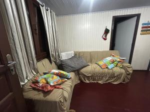 a living room with a couch with pillows on it at Casa da vó in Jaguaruna +4 photos