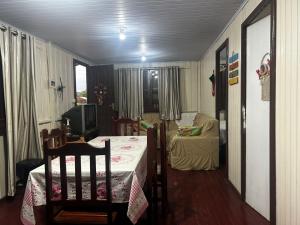 a room with a table and chairs and a couch at Casa da vó in Jaguaruna