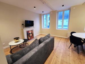 a living room with a couch and tables and a tv at Premium Appartement Hesdin in Hesdin
