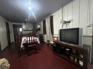 a living room with a television and a dining table at Casa da vó in Jaguaruna
