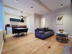 a living room with a couch and a table at Premium Appartement Hesdin in Hesdin +3 photos