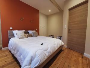 a bedroom with a large white bed and a wooden floor at Premium Appartement Hesdin in Hesdin