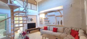 a living room with a couch and a spiral staircase at Aracelia villas with private pool in Siviri