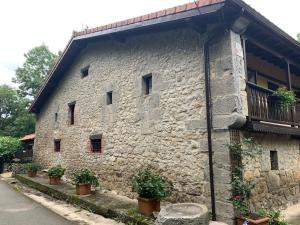 a stone building with potted plants on the side of it at La casa de Chipi Lacavada in La Cavada