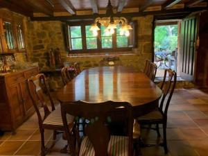 a dining room with a wooden table and chairs at La casa de Chipi Lacavada in La Cavada +28 photos