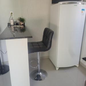 a black chair sitting in a kitchen next to a counter at Apartamento in União da Vitória