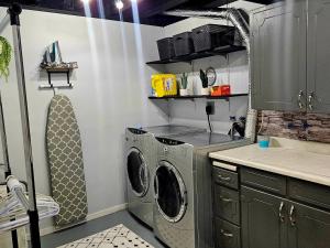 a kitchen with a washing machine and a sink at Queen City Comfort in Regina