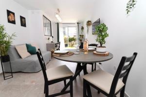 a dining room with a table and chairs and a couch at La Cosy House in Courcouronnes
