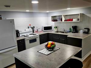 a kitchen with a bowl of fruit on a counter at Queen City Comfort in Regina