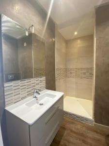 a bathroom with a white sink and a tub at Elégance du Golfe in Vallauris +9 photos