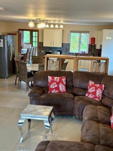 a living room with a brown couch and a kitchen at Brynhyfryd in Aberystwyth