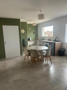 a kitchen and dining room with a table and chairs at Petite maison calme in Dun-sur-Auron