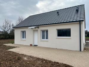 a white house with a black roof at Petite maison calme in Dun-sur-Auron