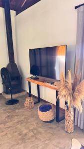 a living room with a table with a tv and a fireplace at Chalé Au Clair de Lune Terê in Teresópolis