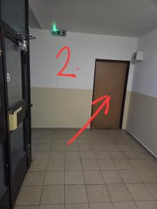 a room with a door with a red arrow on the wall at Apartmán KN in Liptovský Mikuláš