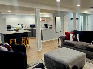 a living room with a couch and a table and a kitchen at Queen City Comfort in Regina
