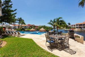 a patio with a table and chairs next to a pool at Aventuras Club Laguna in Puerto Aventuras