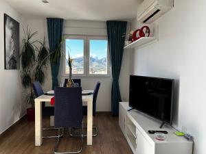 a living room with a dining table and a television at TuttiFruttiaApt in Nerja