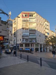 a large building on a city street with people walking in front at TuttiFruttiaApt in Nerja