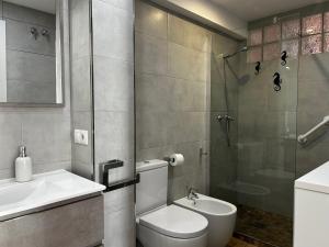 a bathroom with a toilet and a sink and a shower at TuttiFruttiaApt in Nerja +11 photos