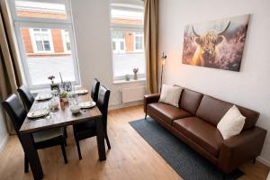 a living room with a couch and a table at N&N Apartments - Studio mit Netflix - Workstation im Zentrum in Schwerin