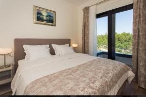 a bedroom with a large bed and a large window at Villa Olive Tree in Vinišće +26 photos