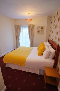 a bedroom with a large bed with yellow pillows at Sunset Suites in Blackpool +3 photos