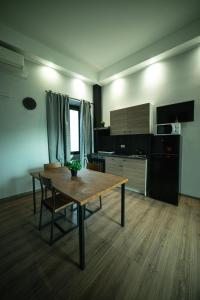 a living room with a wooden table and a kitchen at Chivasso centro - Garden Apartments in Chivasso