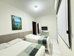 a hospital room with two beds and a television at Pousada DONA LÍDIA in Campo Mourão