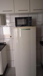 a microwave on top of a refrigerator in a kitchen at Pousada DONA LÍDIA in Campo Mourão +10 photos