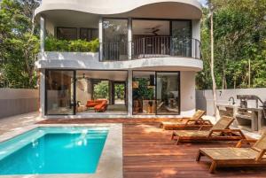 a house with a swimming pool and a deck with chairs at Luxury 4BR Eco Villa 10ppl Outdoor Pizza Oven - Private Pool & Jacuzzi in Tulum +24 photos