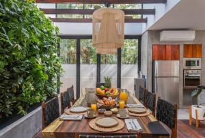a dining room table with a bowl of fruit on it at Luxury 4BR Eco Villa 10ppl Outdoor Pizza Oven - Private Pool & Jacuzzi in Tulum